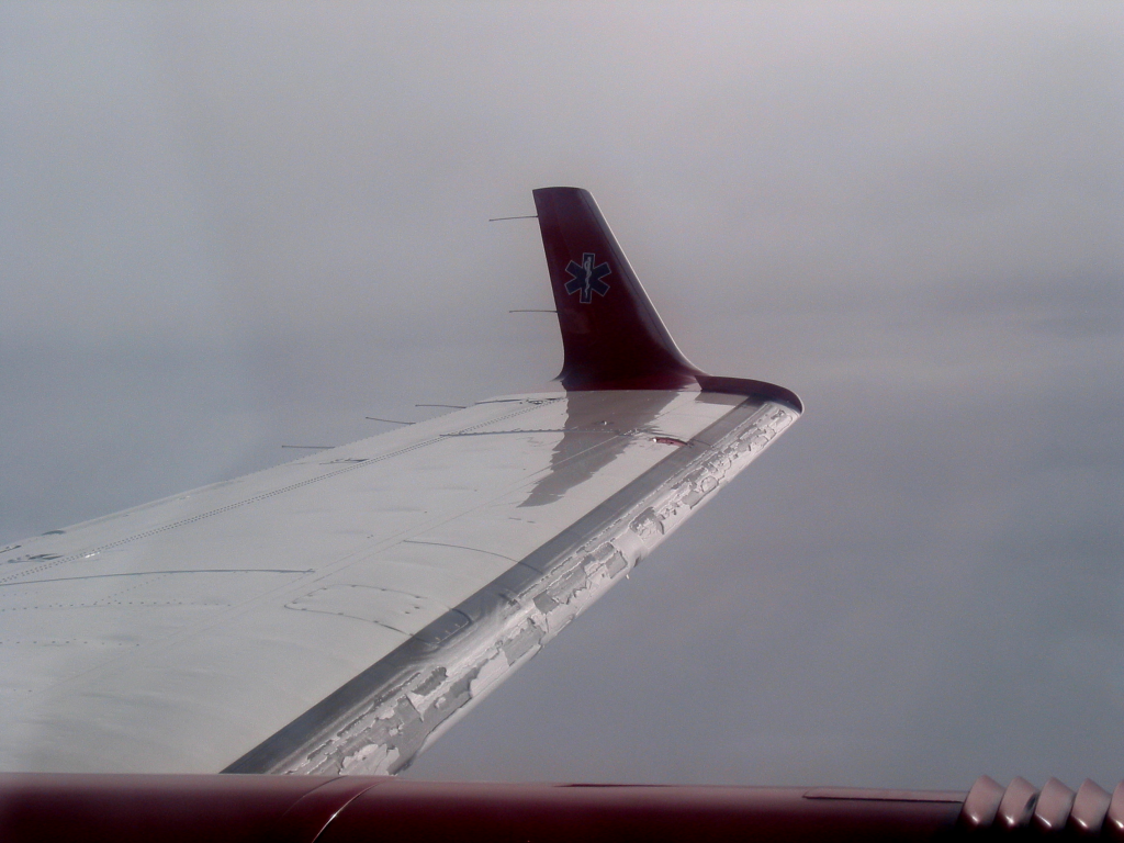 Ice buildup on an aircraft wing caused by supercooled water droplets freezing upon impact.
